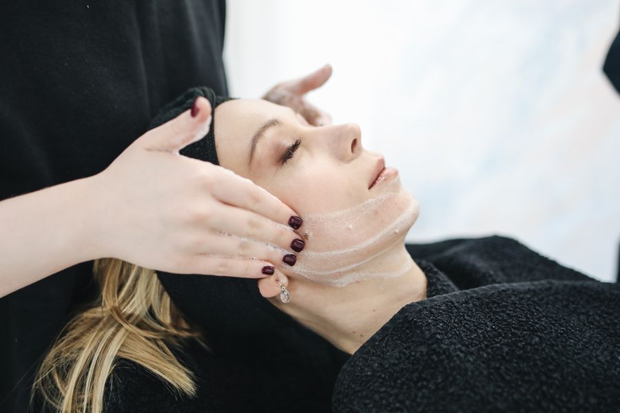 Therapist performing a cleansing facial treatment