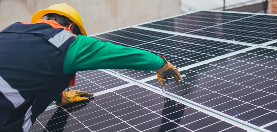 Technician checking solar panel output readings on a tablet